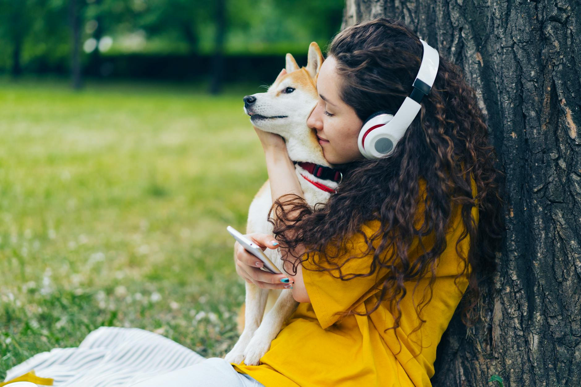 woman sitting and hugging shiba inu dog